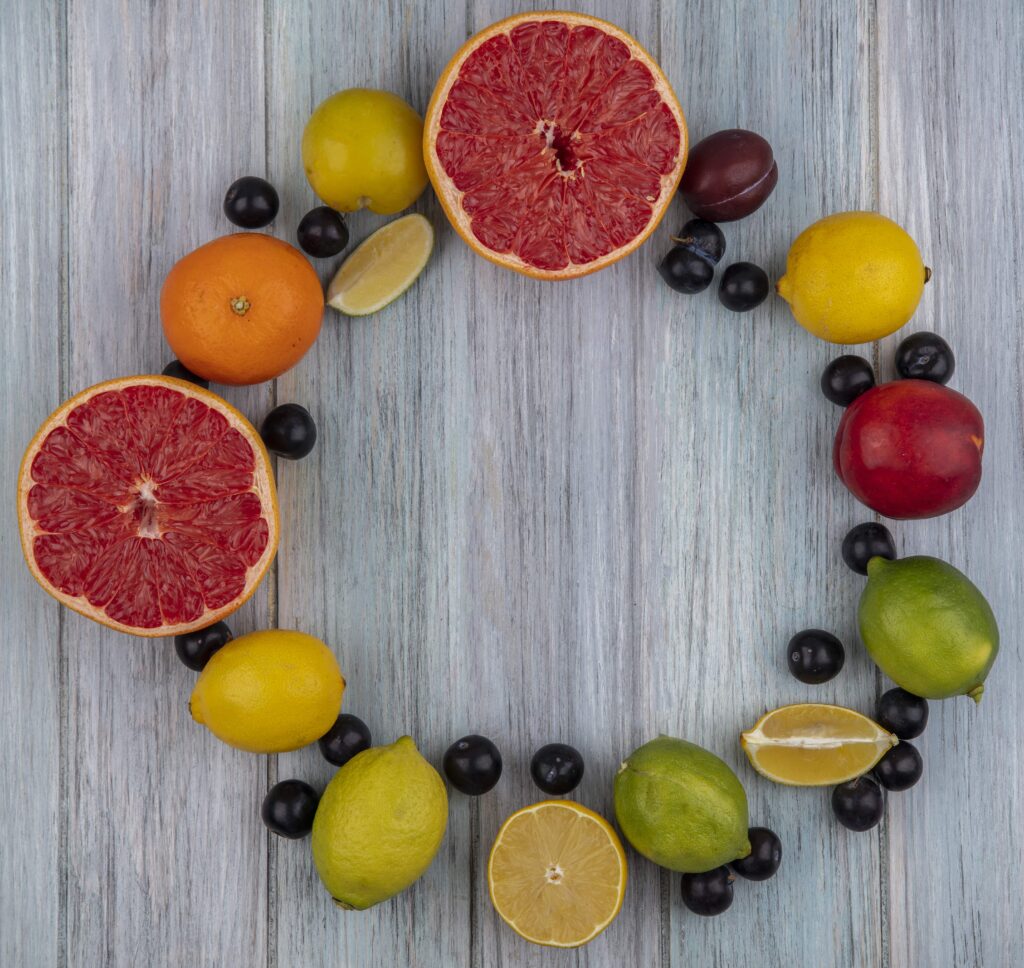 top view copy space grapefruit halves with cherry plum orange peach plum lemon lime gray background min